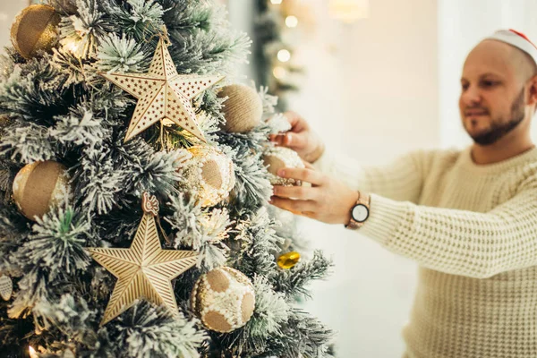 Homme heureux décorant le sapin de Noël à la maison — Photo