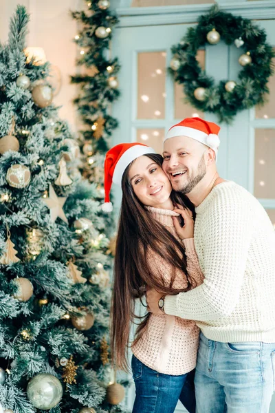 幸福的情侣在圣诞节那天站在装饰树的前面微笑 — 图库照片
