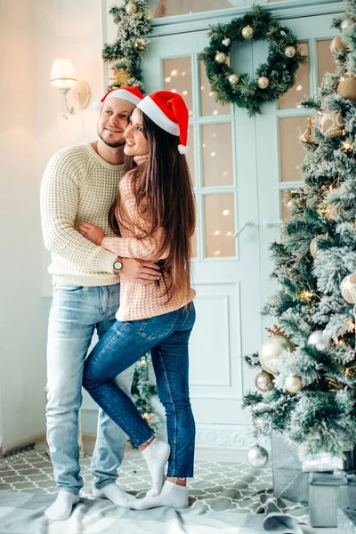幸福的情侣在圣诞节那天站在装饰树的前面微笑 — 图库照片