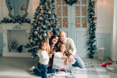 miling genç aile fotoğraf ile smartphone yapma Noel atmosferi içinde