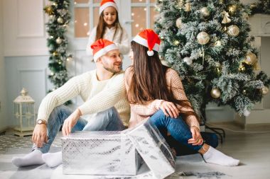 Noel ağacının önünde aile alışverişi.