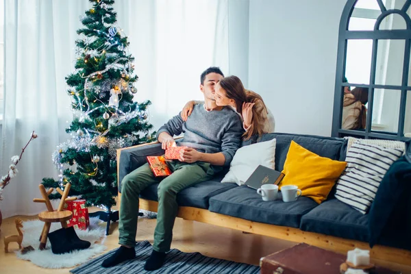 Mladý pár s dary před vánoční stromeček — Stock fotografie