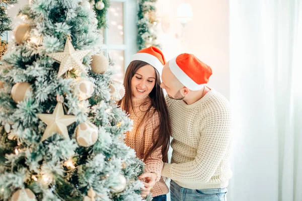 Söt, ung par dekorera en julgran — Stockfoto