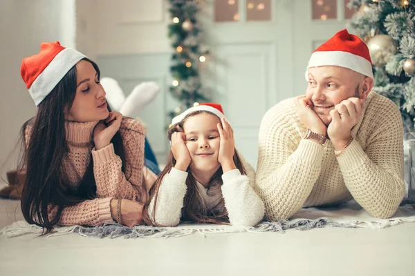 ベッドの上に横たわるクリスマス サンタ帽子の家族。母父と楽しんで赤ちゃん — ストック写真
