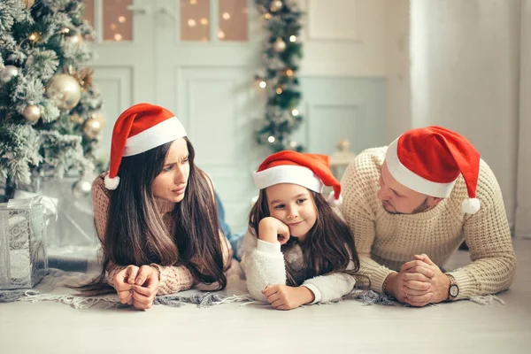 Οικογένεια με καπέλο Santa που βρίσκεται κοντά στο χριστουγεννιάτικο δέντρο, διακοπές γιορτή έννοια — Φωτογραφία Αρχείου