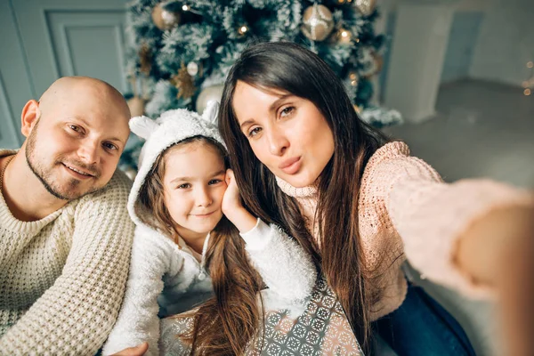 Jonge gelukkig gezin van vier nemen van een foto van zichzelf door een open haard — Stockfoto