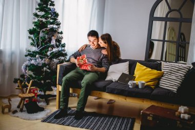 adam bir hediye kutusu oturan kız arkadaşı süre açılış üzerinde onu kanepeye kapatın