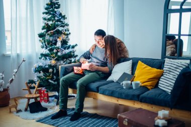 adam bir hediye kutusu oturan kız arkadaşı süre açılış üzerinde onu kanepeye kapatın