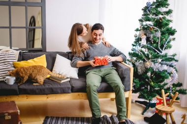 Neşeli erkek ve kadın açar Noel hediyesi