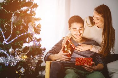 Young woman with husband looking at Christmas gift clipart
