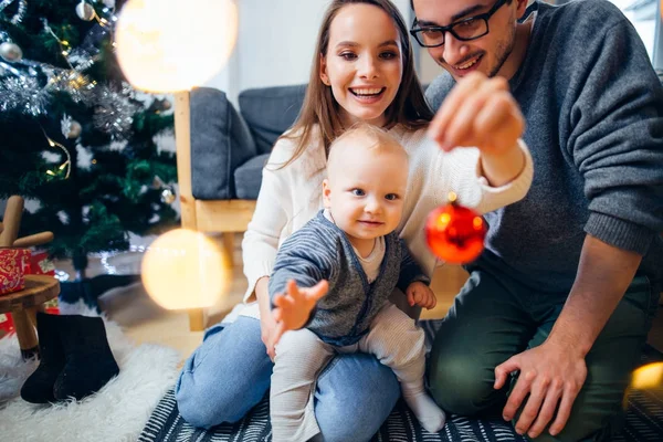 Happy family playing with Christmas balls at home