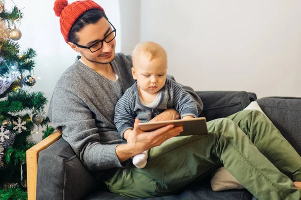 Bebê com o pai sentado e usando tablet digital durante o Natal — Fotografia de Stock