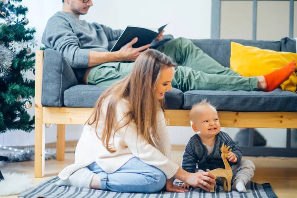 Feliz familia madre y bebé pequeño hijo jugando en casa en las vacaciones de Navidad —  Fotos de Stock