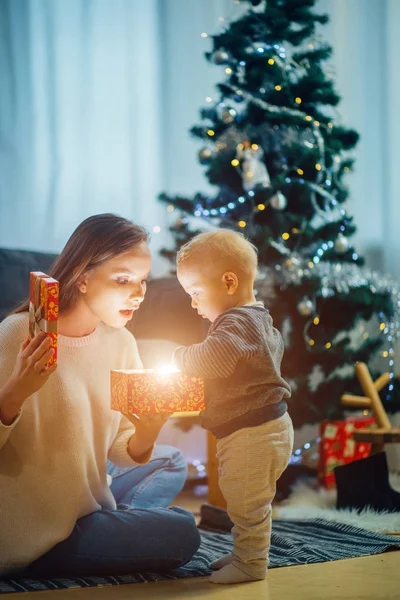 母親と赤ちゃんの近くにクリスマス ツリー、幸せな休日の概念、家族の肖像画 — ストック写真