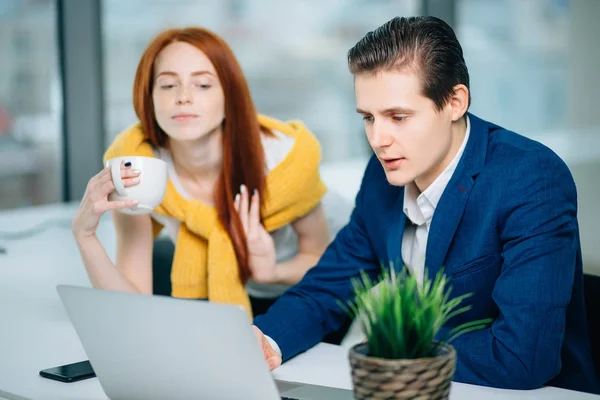 Businesswoman and businessman talking at work in office