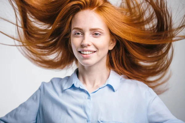 Портрет красивой веселой рыжей девушки с летающими волосами, улыбающейся смеясь — стоковое фото