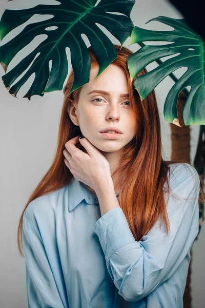 Bella rossa ragazza copertina con foglie verdi. — Foto Stock