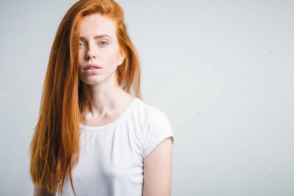 redhead girl with healthy freckled skin looking at camera