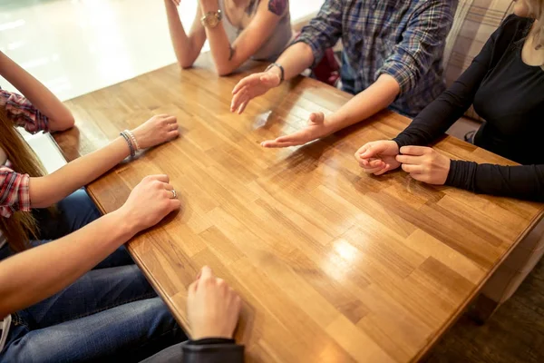 Grupo de estudiantes sentados en un bar mirándose el uno al otro — Foto de Stock