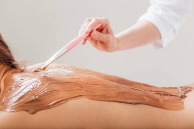 Güzellik salonunda kozmetik maske takan genç bir kadın için kaplıca terapisi