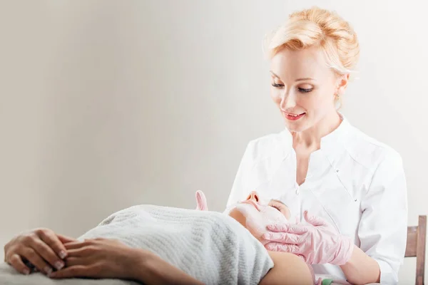 Joven hermosa chica en máscara para la cara relajante en el salón de spa . — Foto de Stock