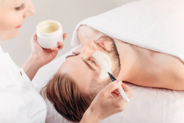 Hombre con máscara cosmética en el salón de spa — Foto de Stock