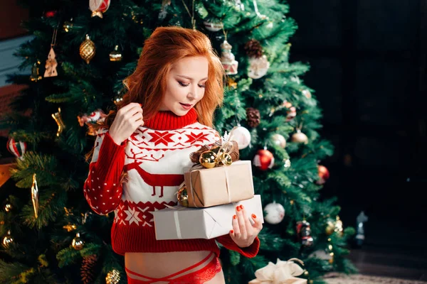Sexy mujer joven en suéter se está preparando para celebrar el Año Nuevo en casa —  Fotos de Stock