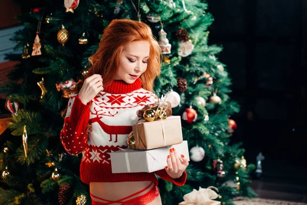 Sexy jonge vrouw in trui bereidt voor Nieuwjaar vieren thuis — Stockfoto