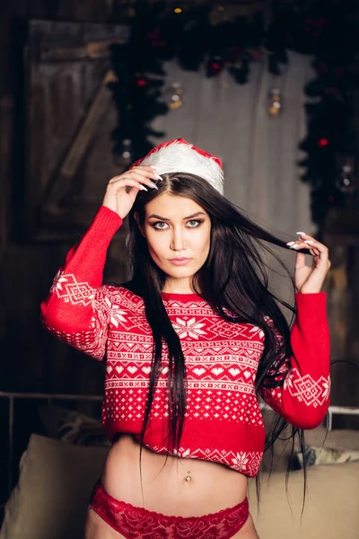 Kobieta w Christmas sweter. Dziewczyna z makijażu i ciemne kręcone fryzury w domu — Zdjęcie stockowe
