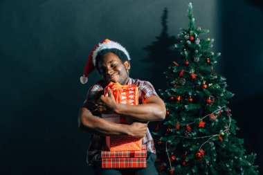 Noel hediyesi elinde tutan çekici gülümseme ile Afro Amerikan adam