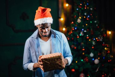 Noel hediyesi elinde tutan çekici gülümseme ile Afro Amerikan adam