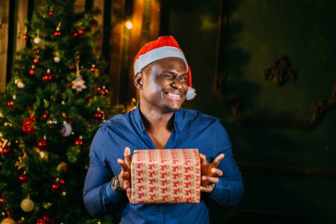 Noel hediyesi elinde tutan çekici gülümseme ile Afro Amerikan adam