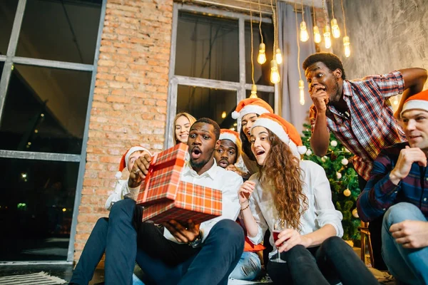 Lyckligt leende vänner öppna magiska julklapp — Stockfoto