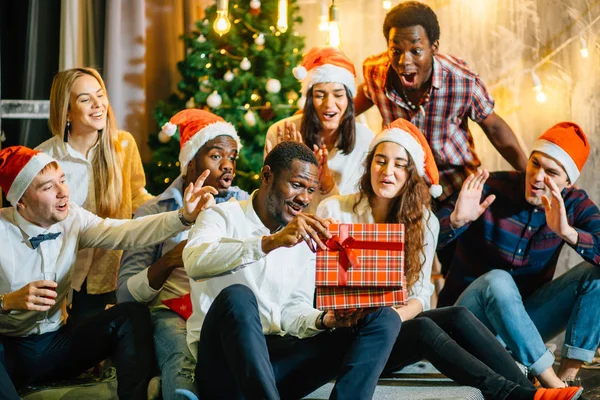 Felices amigos sonrientes abriendo magia regalo de Navidad — Foto de Stock