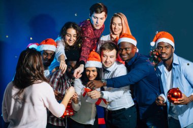 Yeni yıl birlikte kutluyor. Noel Baba şapkaları içinde güzel gençlerin grup