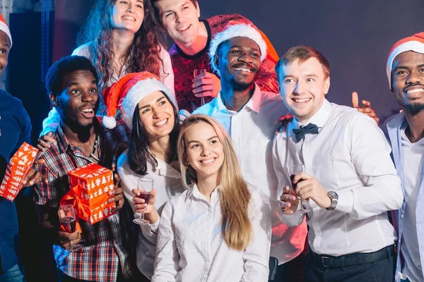 Grupo de jóvenes hermosos en los sombreros de Santa mirando a un lado — Foto de Stock