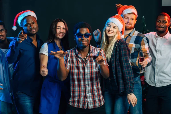 Celebrando el Año Nuevo juntos. Grupo de jóvenes hermosos en los sombreros de Santa — Foto de Stock