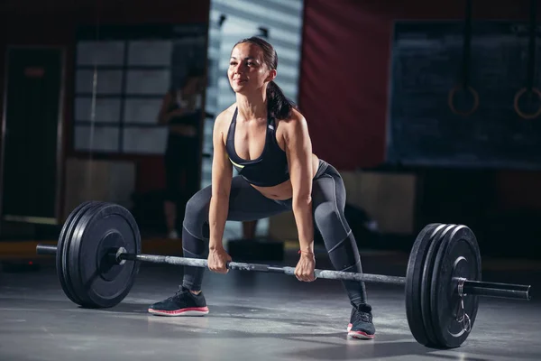 Vrouw beginnen barbell oefening staande squat houding. — Stockfoto