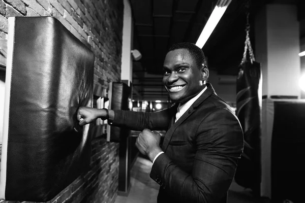 person wearing business suit and boxing gloves.