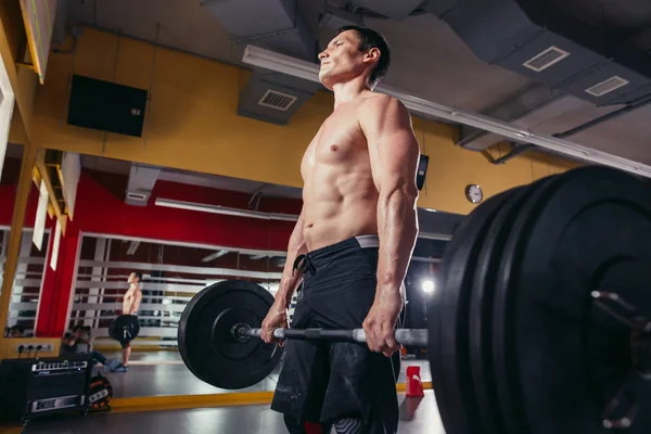 Gespierde man doen squats oefening met barbell — Stockfoto