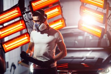 koruyucu maske ve gözlük parlatma makinesi tutan adam