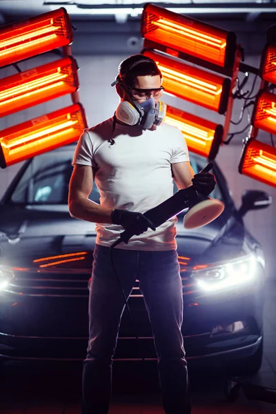 Homem vestindo máscara protetora e óculos segurando máquina de polimento — Fotografia de Stock