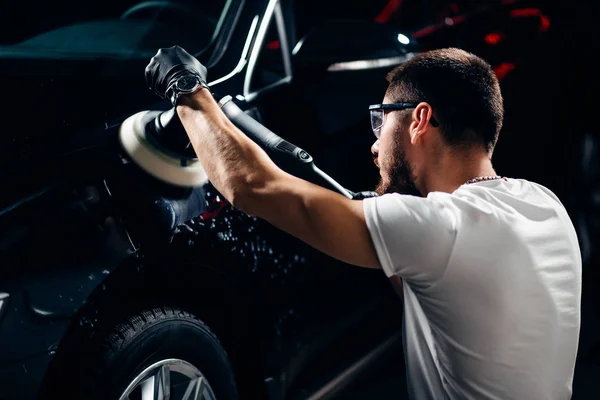 Auto detaillering - man met orbitale polijstmachine in auto reparatiewerkplaats. Selectieve aandacht. — Stockfoto