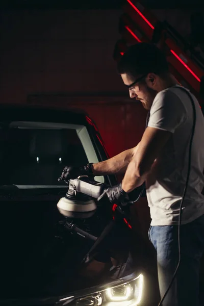 Auto podrobně - muž s orbitální leštička v automatické opravna. Selektivní fokus. — Stock fotografie