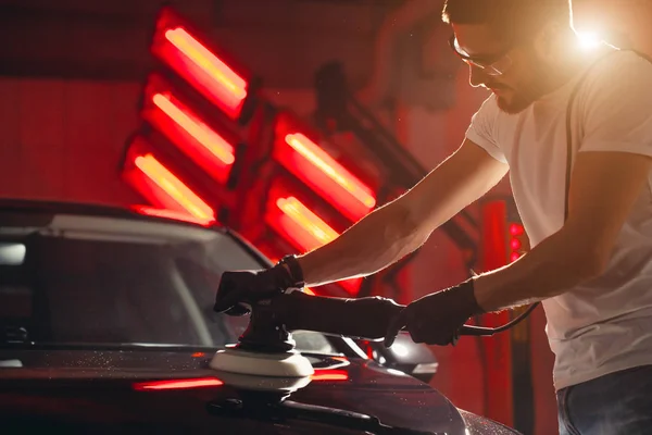 Detalles del coche - hombre con pulidor orbital en taller de reparación de automóviles. Enfoque selectivo . — Foto de Stock