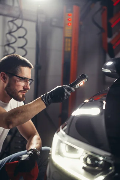 Man checks polishing with a torch — Stock Photo, Image