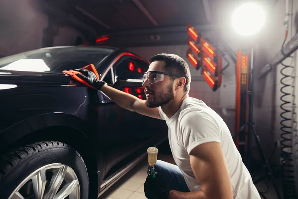 Détail de la voiture - l'homme tient la microfibre à la main et polit la voiture — Photo