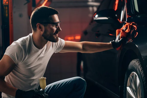 Détail de la voiture - l'homme tient la microfibre à la main et polit la voiture — Photo