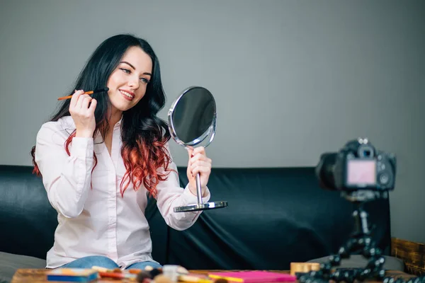 Female blogger with makeup cosmetics recording video at home — Stock Photo, Image