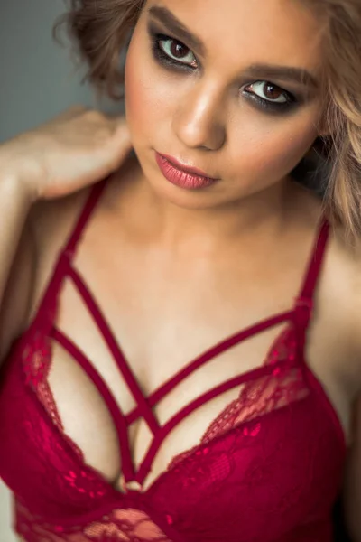 Сексуальная девушка в красном белье позирует в спальне — стоковое фото
